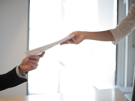 Business person being passed papers